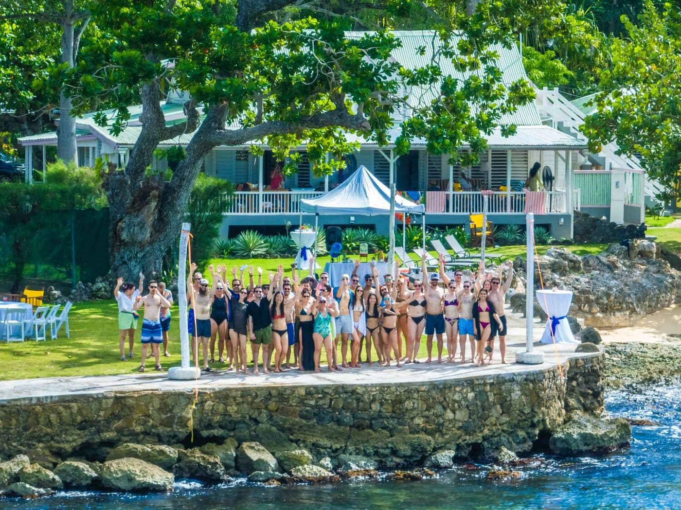 A large group gathered on the seaside lawn in front of the great house