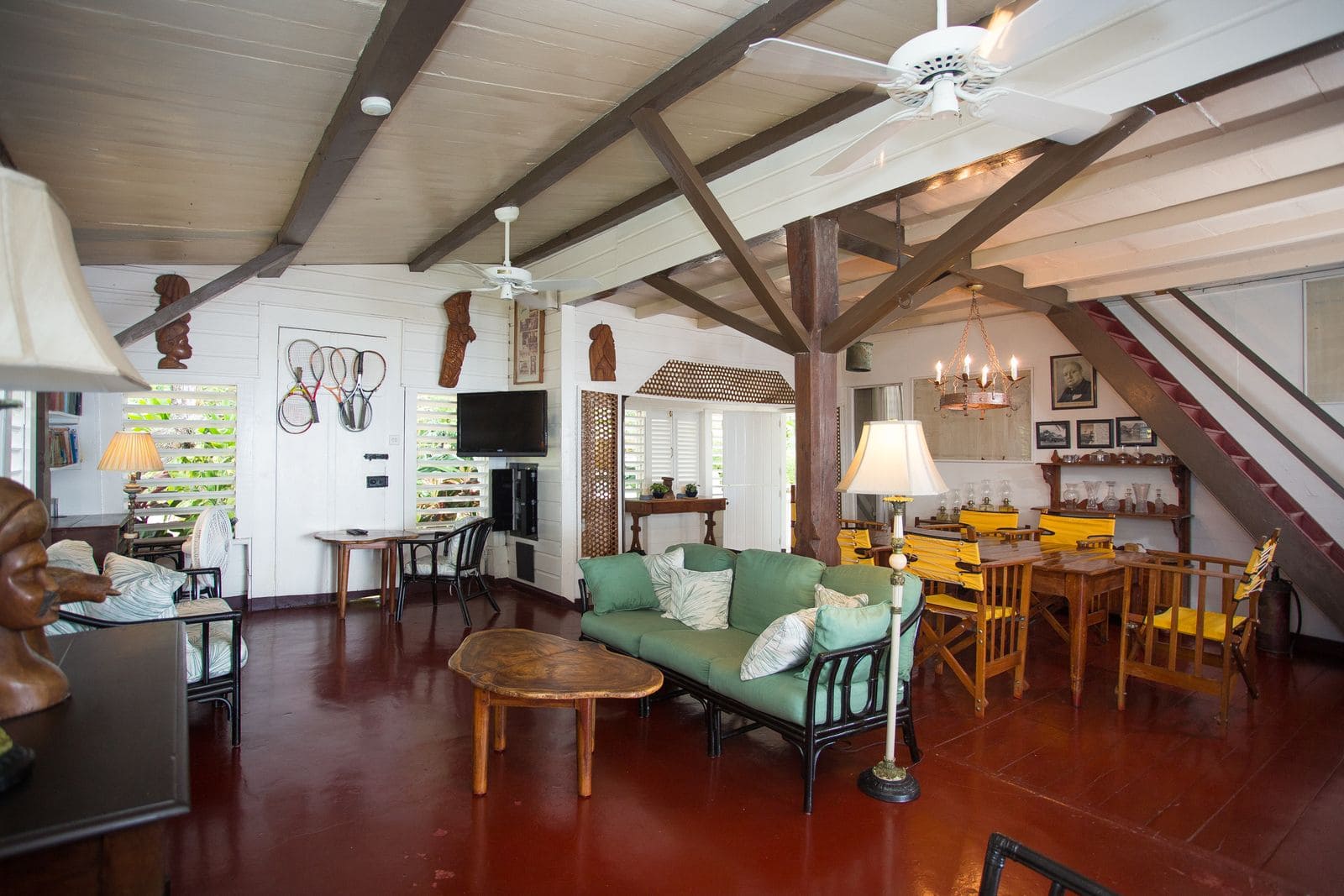The great room with beamed ceiling, sofas and dining table