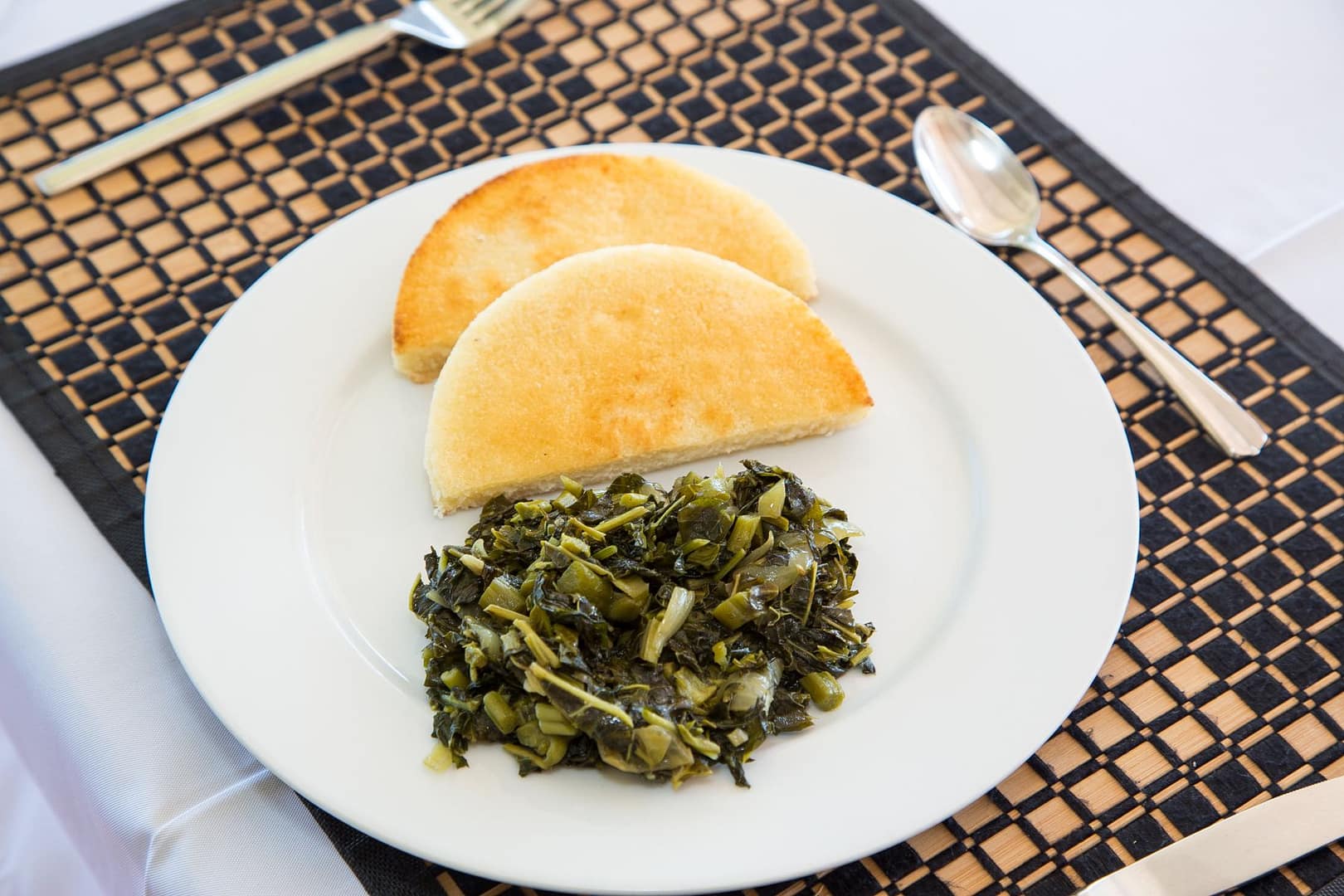 Golden festival dumplings with sautéed callaloo