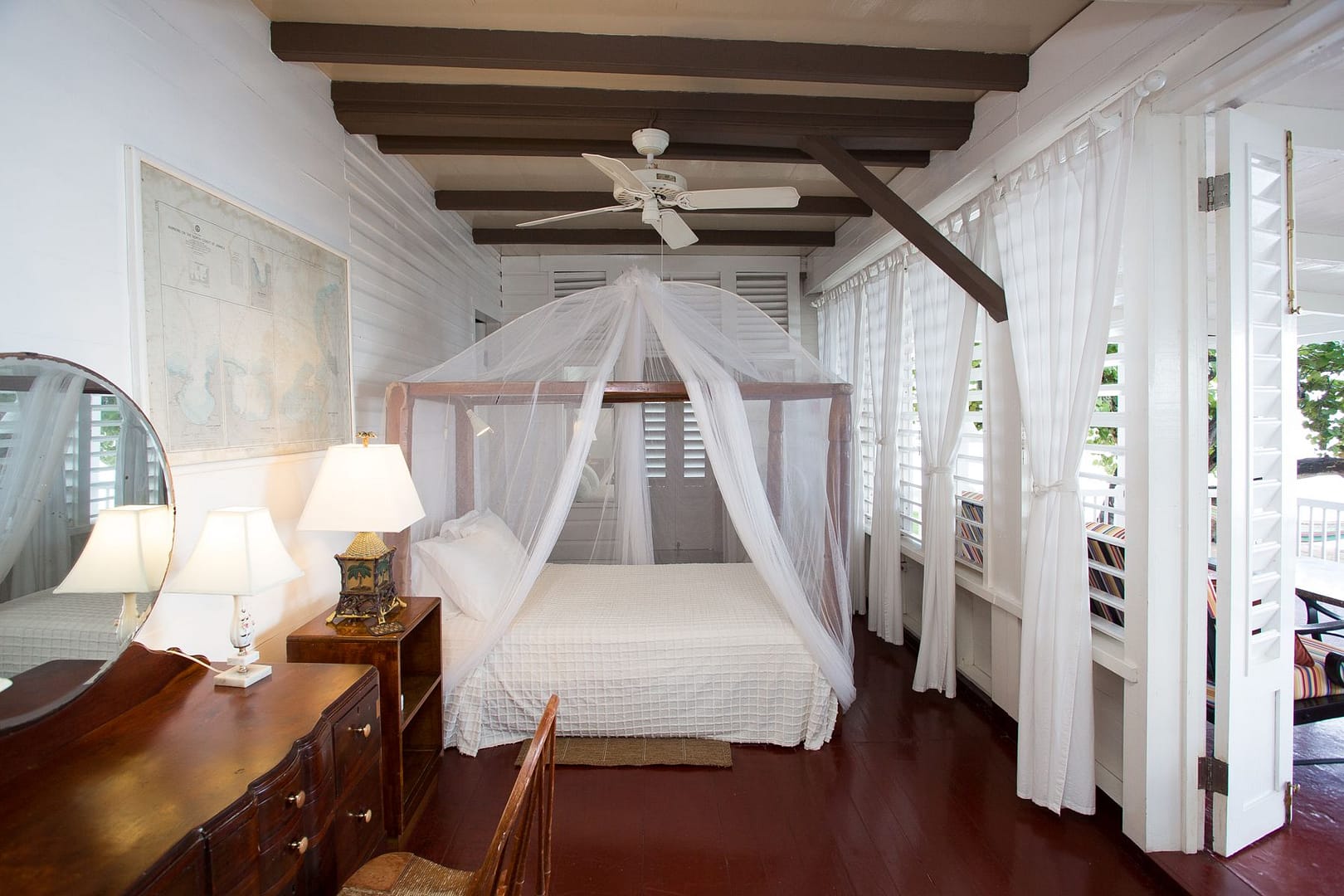 The Seaside Master Suite: a netted four-poster bed and louvred doors open to the veranda