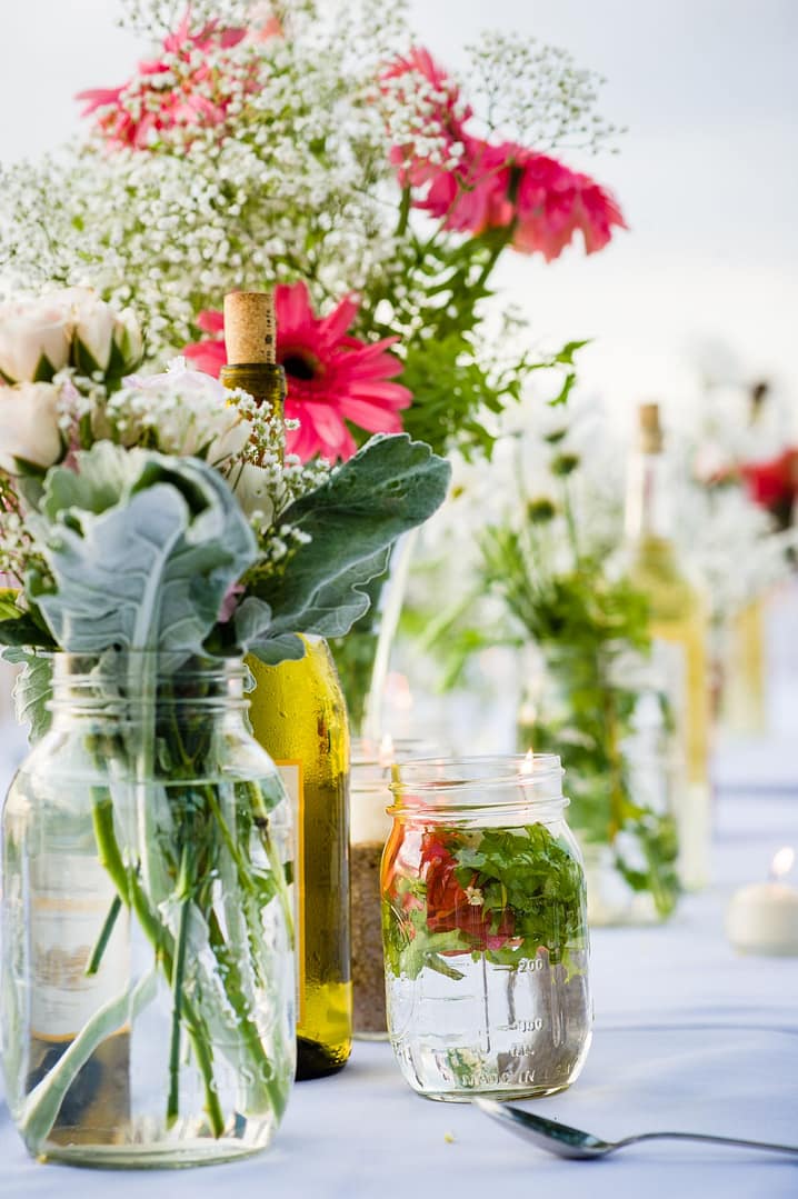 Jars of bright tropical flowers on a reception table